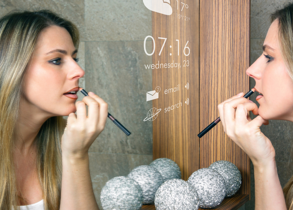 Woman applying makeup in mirror, which is showing weather for the day